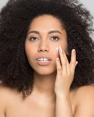 Model applying a cream to her face.