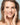 Model touching her face with a light blue background.