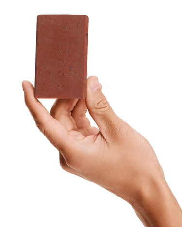 Image of a model holding a bar of Antü Restoring Soap.