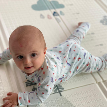 Bébé habillé avec son pyjama de la collection mer se baladant sur son tapis de jeu. Bébé à l'aise et confortable dans son pyjama.