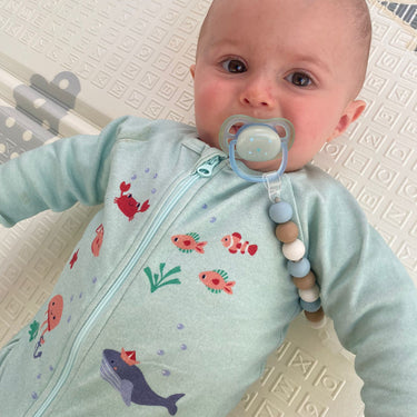 Bébé vêtu du pyjama "nager au mileu des coraux" de la collection mer.