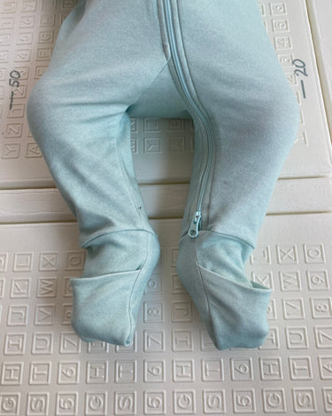 Focus sur les pieds de bébé portant le pyjama avec les chaussettes fermées.